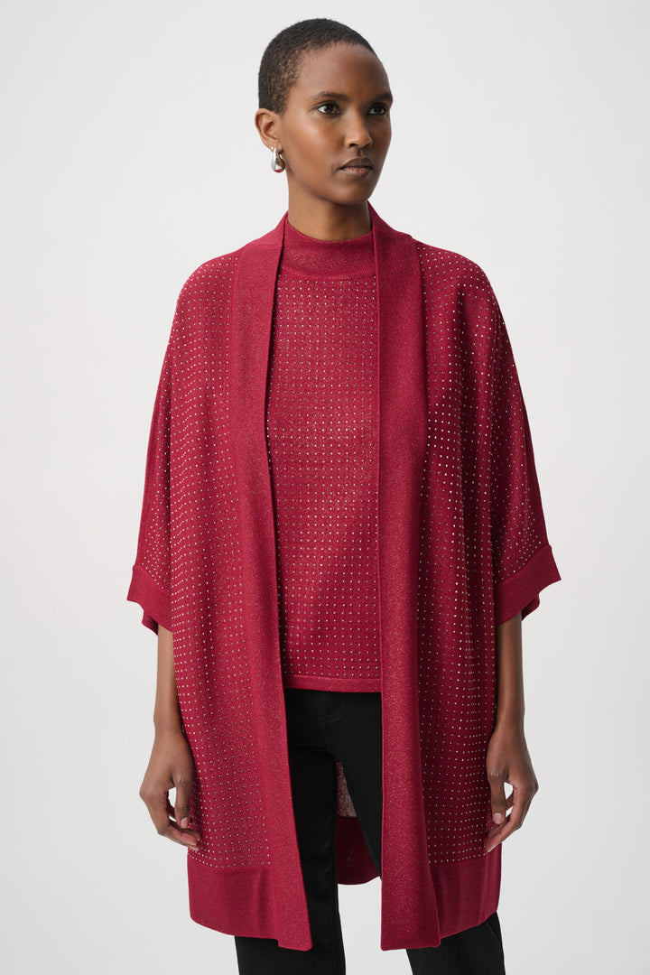 Woman wearing a red rhinestone cardigan with a matching top over a black pants on a white background