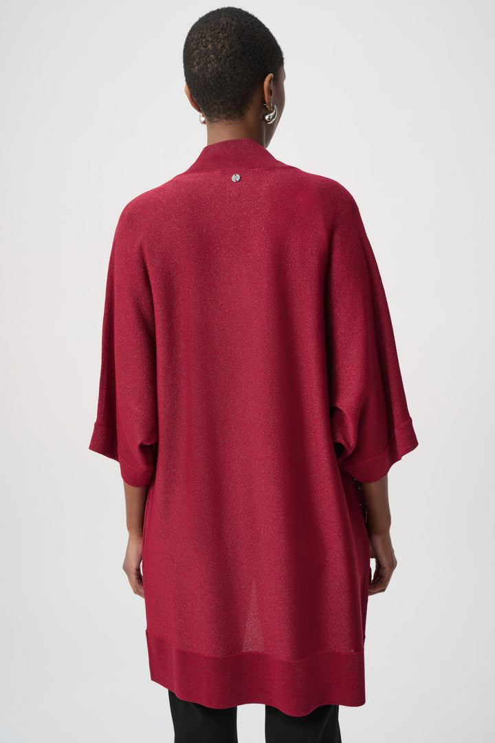 Woman shown from the back wearing a red rhinestone cardigan with a matching top over a black pants on a white background
