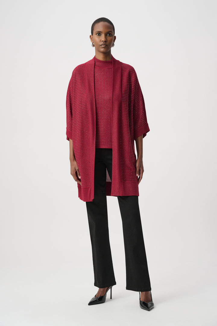 Woman wearing a red rhinestone cardigan with a matching top over a black pants on a white background