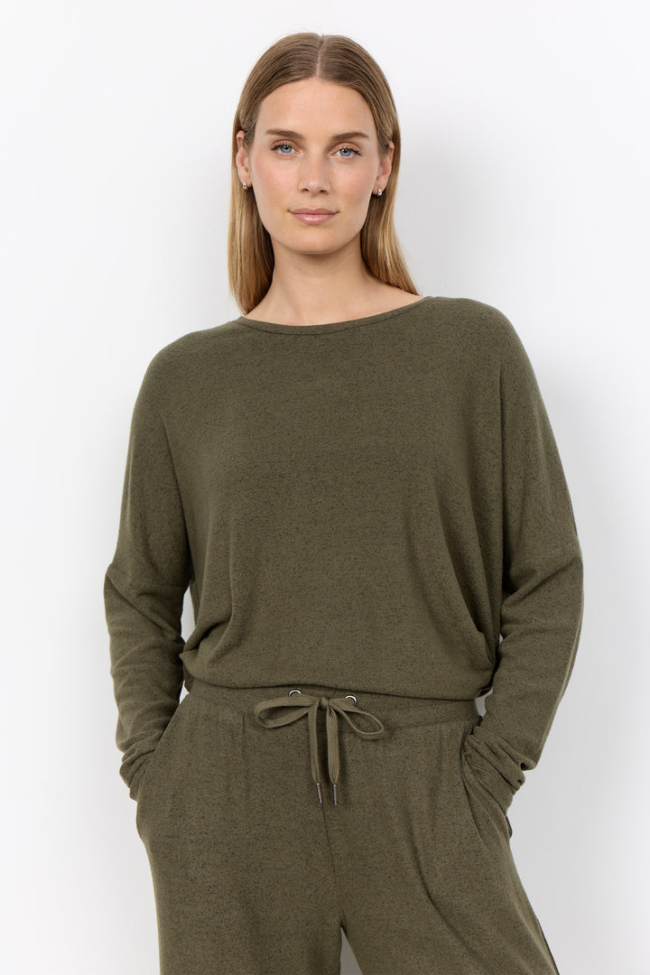 woman wearing an oversized long sleeve sweater with matching pants on a white background. 