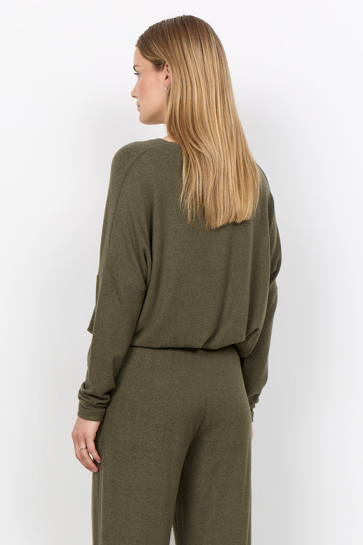 woman wearing an oversized long sleeve sweater with matching pants on a white background. 