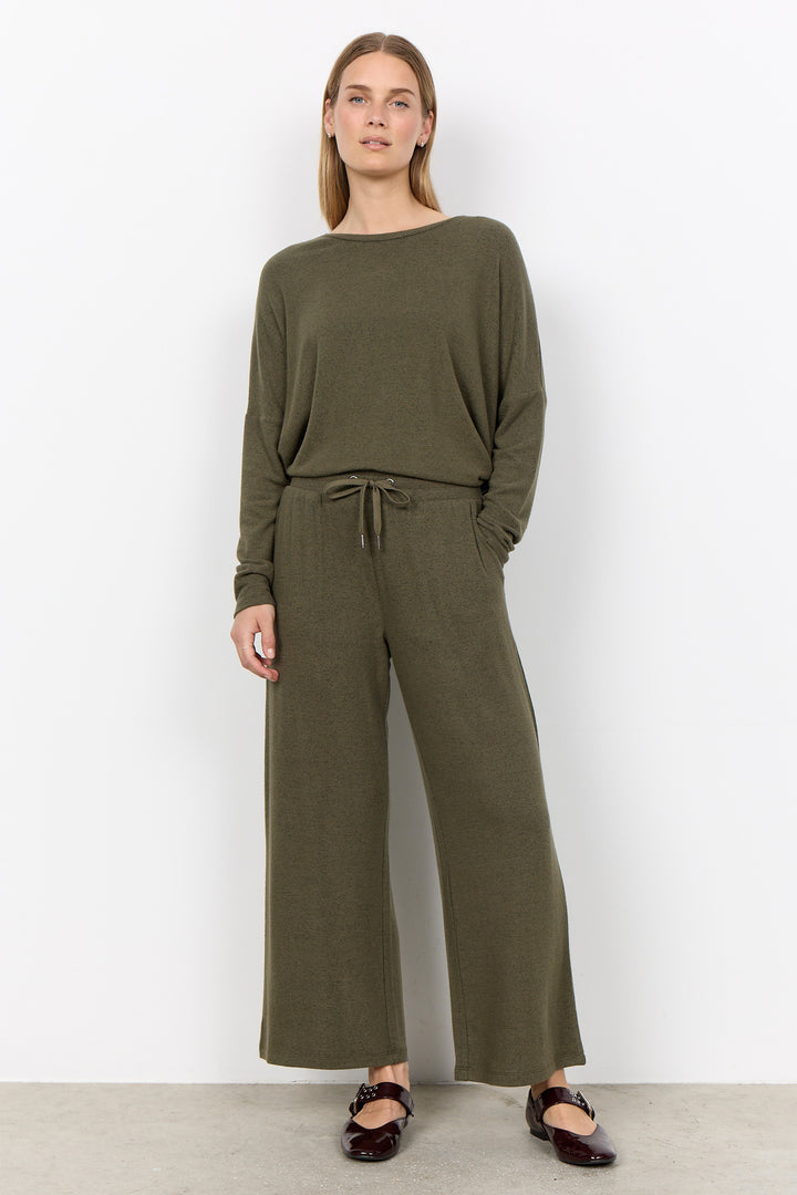 woman wearing an oversized long sleeve sweater with matching pants on a white background. 