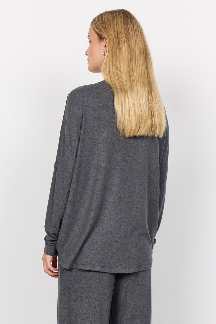 woman wearing an oversized long sleeve sweater with matching pants on a white background. 