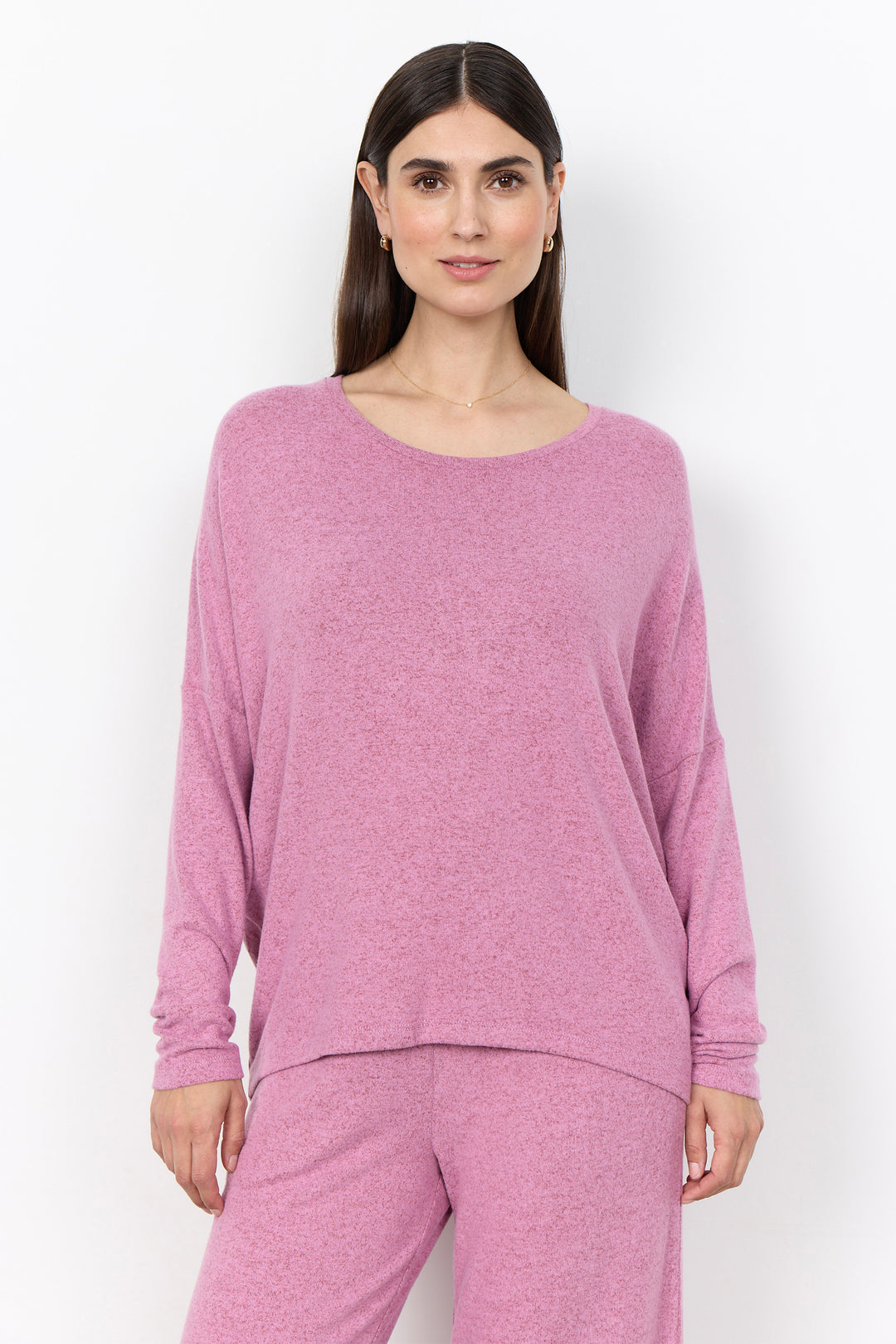 woman wearing an oversized long sleeve sweater with matching pants on a white background. 
