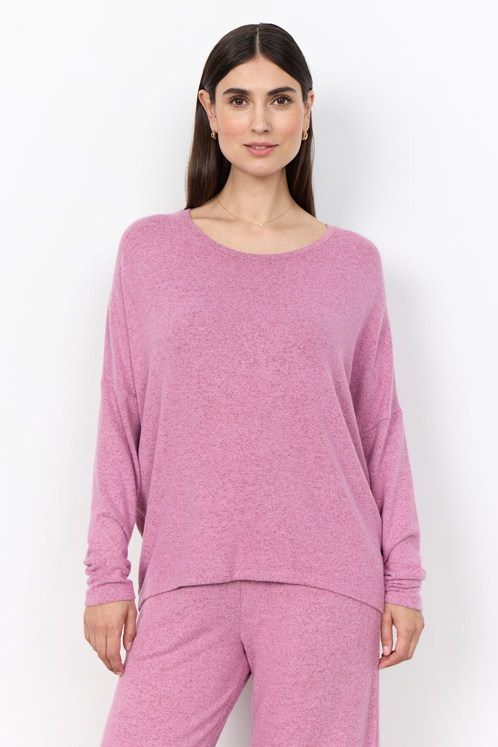 woman wearing an oversized long sleeve sweater with matching pants on a white background. 