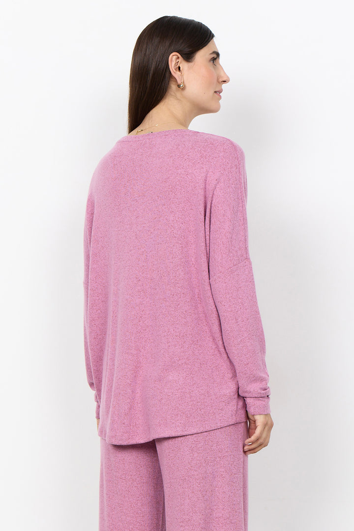 woman wearing an oversized long sleeve sweater with matching pants on a white background. 