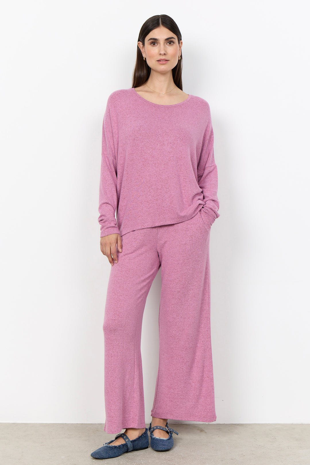 woman wearing an oversized long sleeve sweater with matching pants on a white background. 