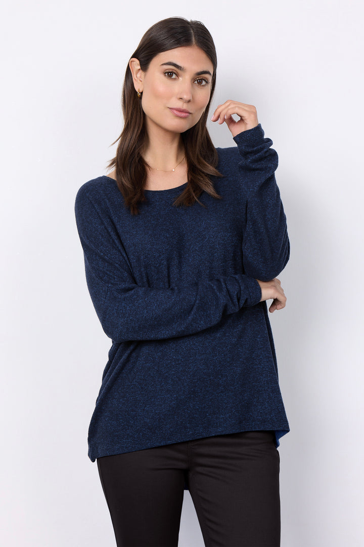 woman wearing an oversized long sleeve sweater with matching pants on a white background. 