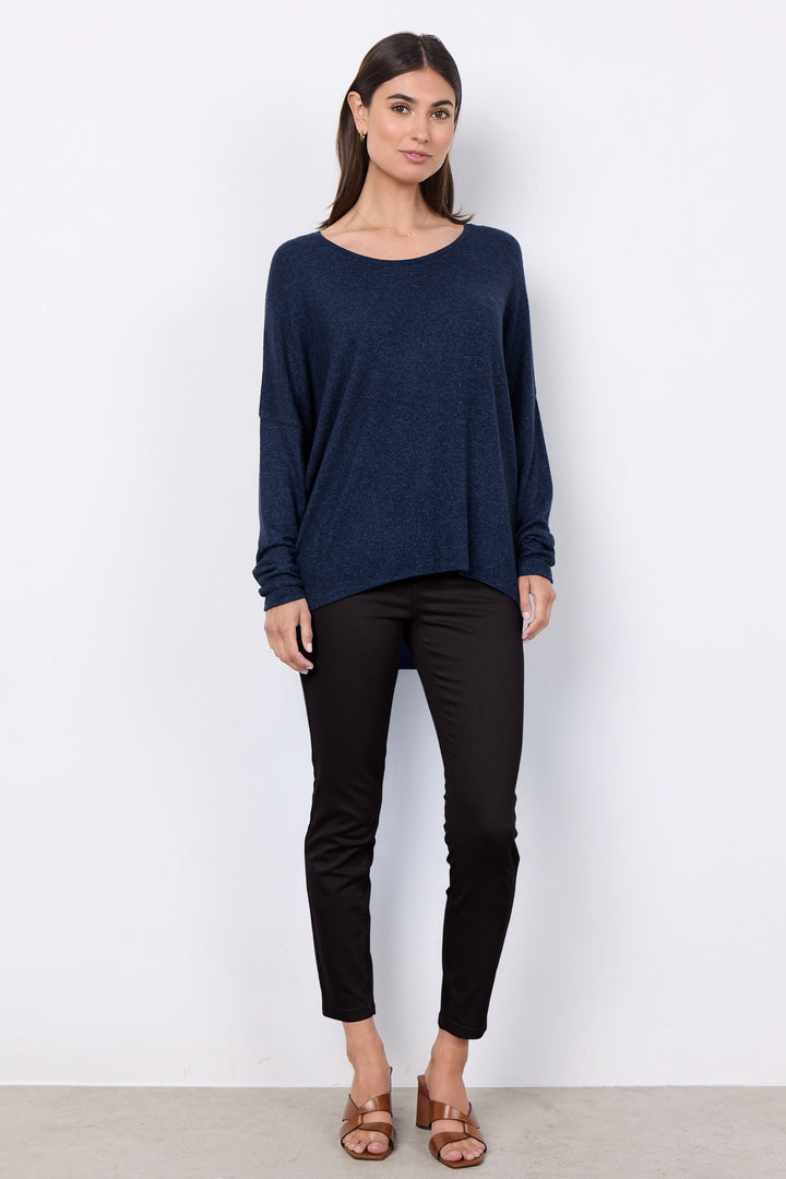 woman wearing an oversized long sleeve sweater with matching pants on a white background. 