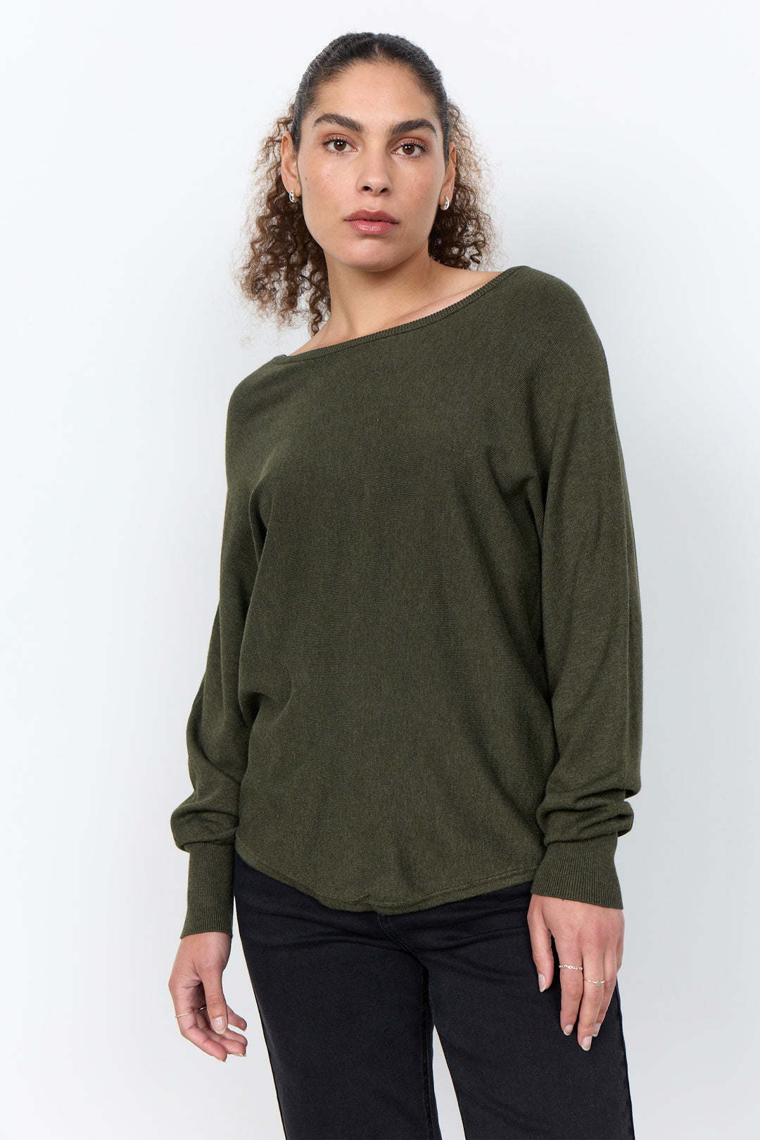 woman wearing a loose long sleeve sweater on a white background. 