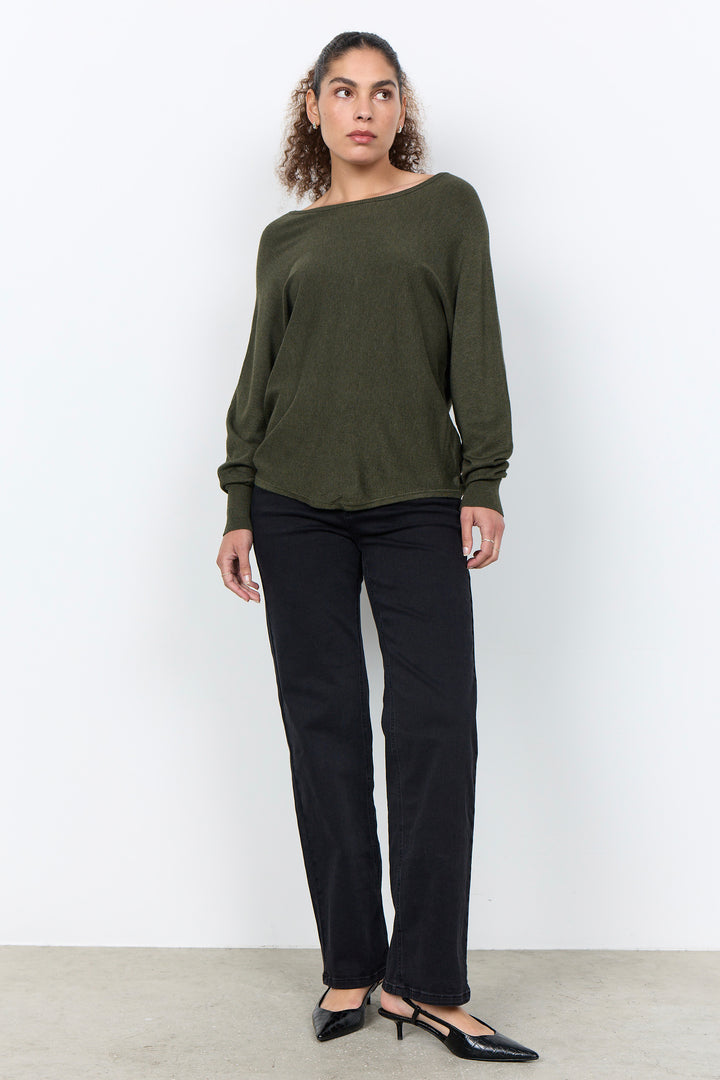woman wearing a loose long sleeve sweater on a white background. 
