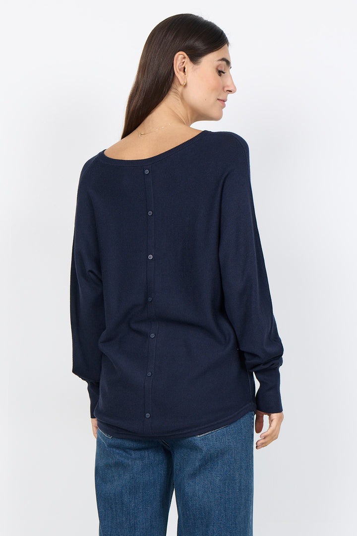 woman wearing a loose long sleeve sweater on a white background. 