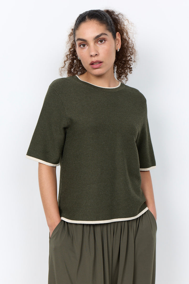 woman wearing a casual ribbed t-shirt sweater on a white background.