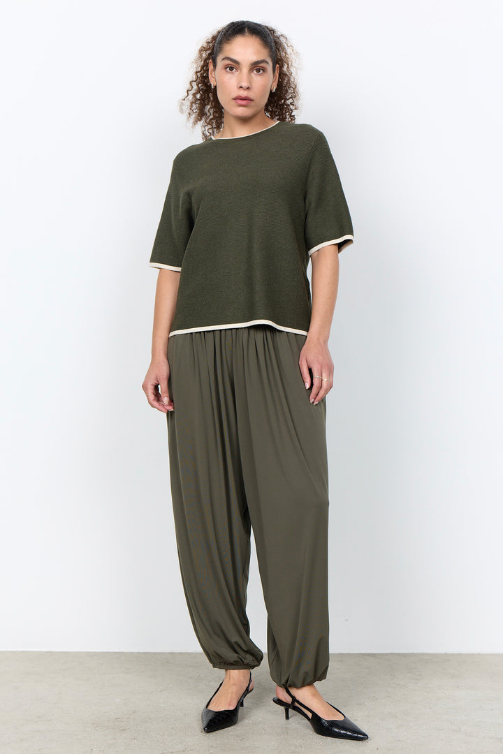 woman wearing a casual ribbed t-shirt sweater on a white background.