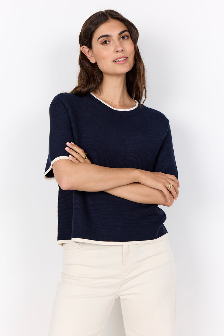 woman wearing a casual ribbed t-shirt sweater on a white background.