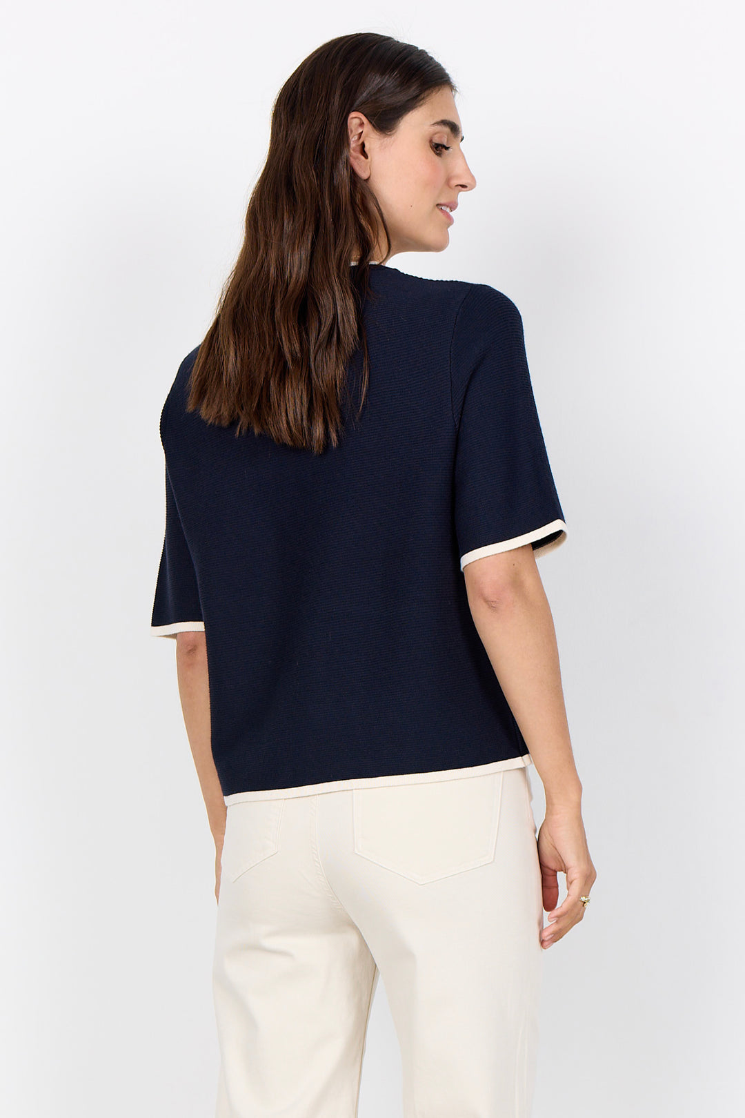 woman wearing a casual ribbed t-shirt sweater on a white background.