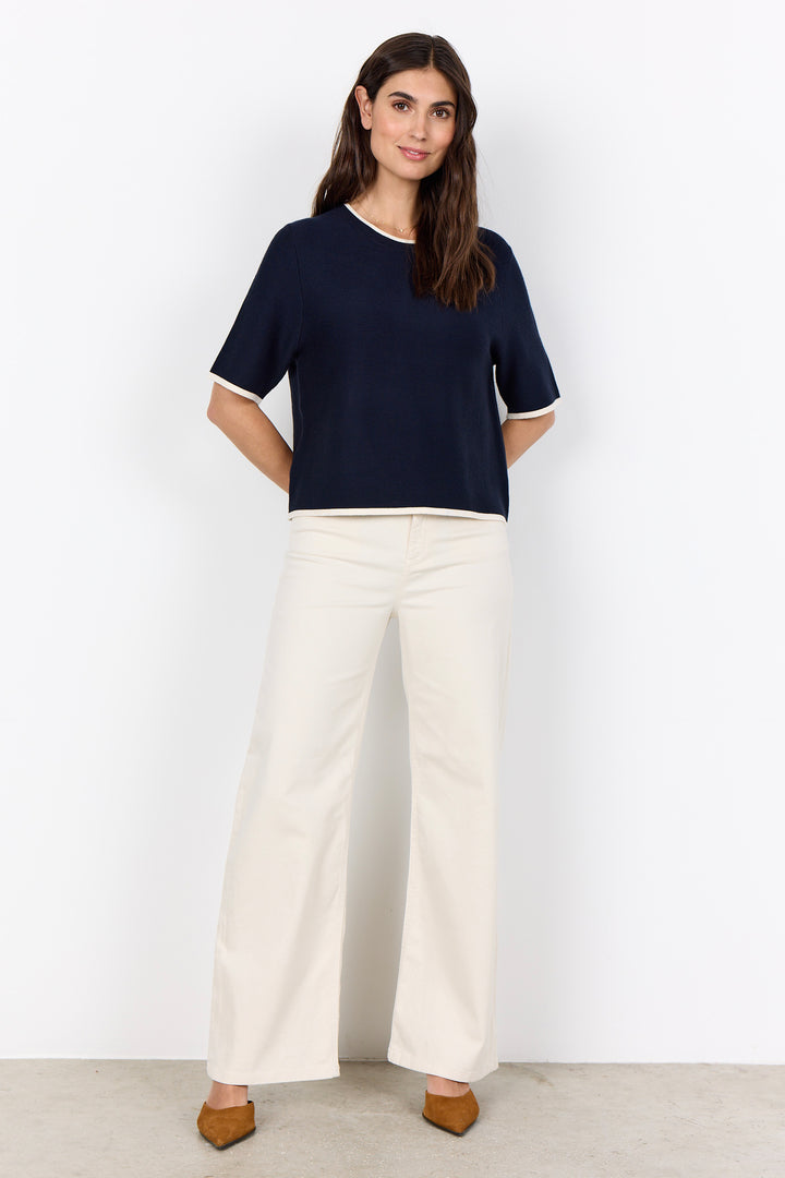 woman wearing a casual ribbed t-shirt sweater on a white background.