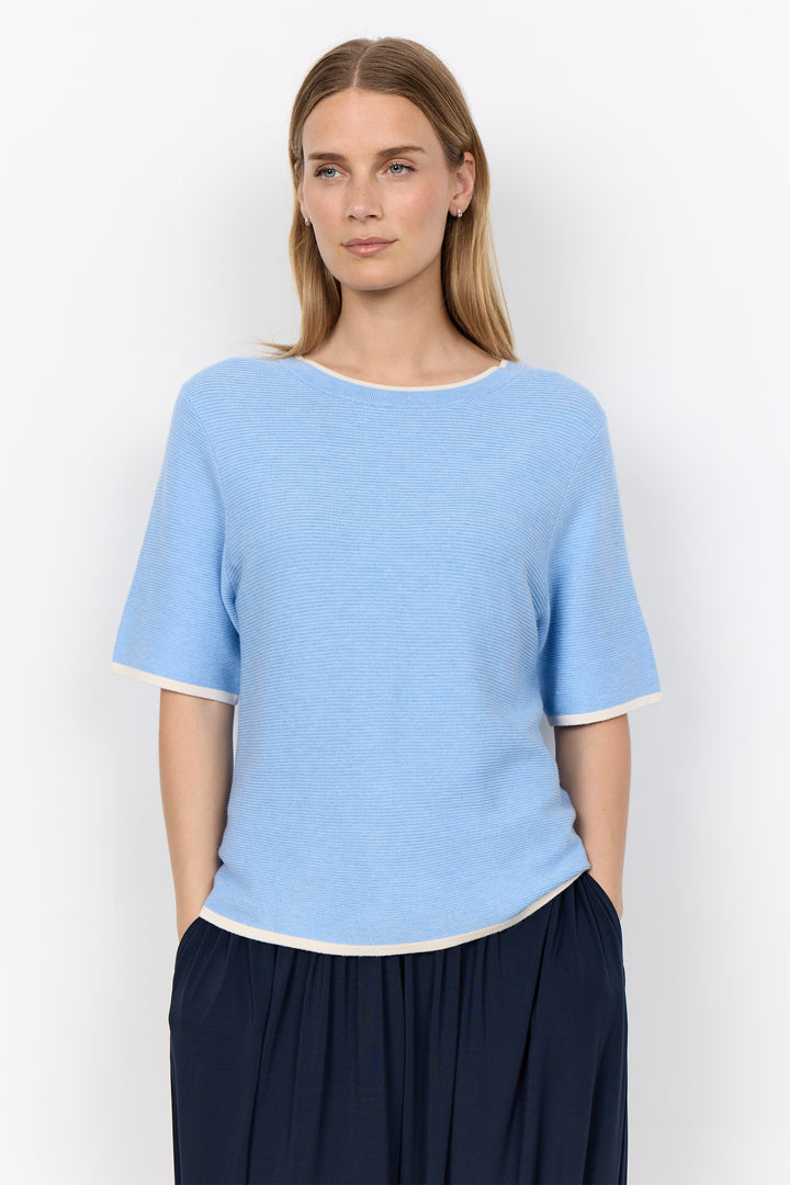 woman wearing a casual ribbed t-shirt sweater on a white background.