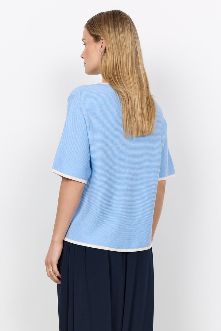 woman wearing a casual ribbed t-shirt sweater on a white background.