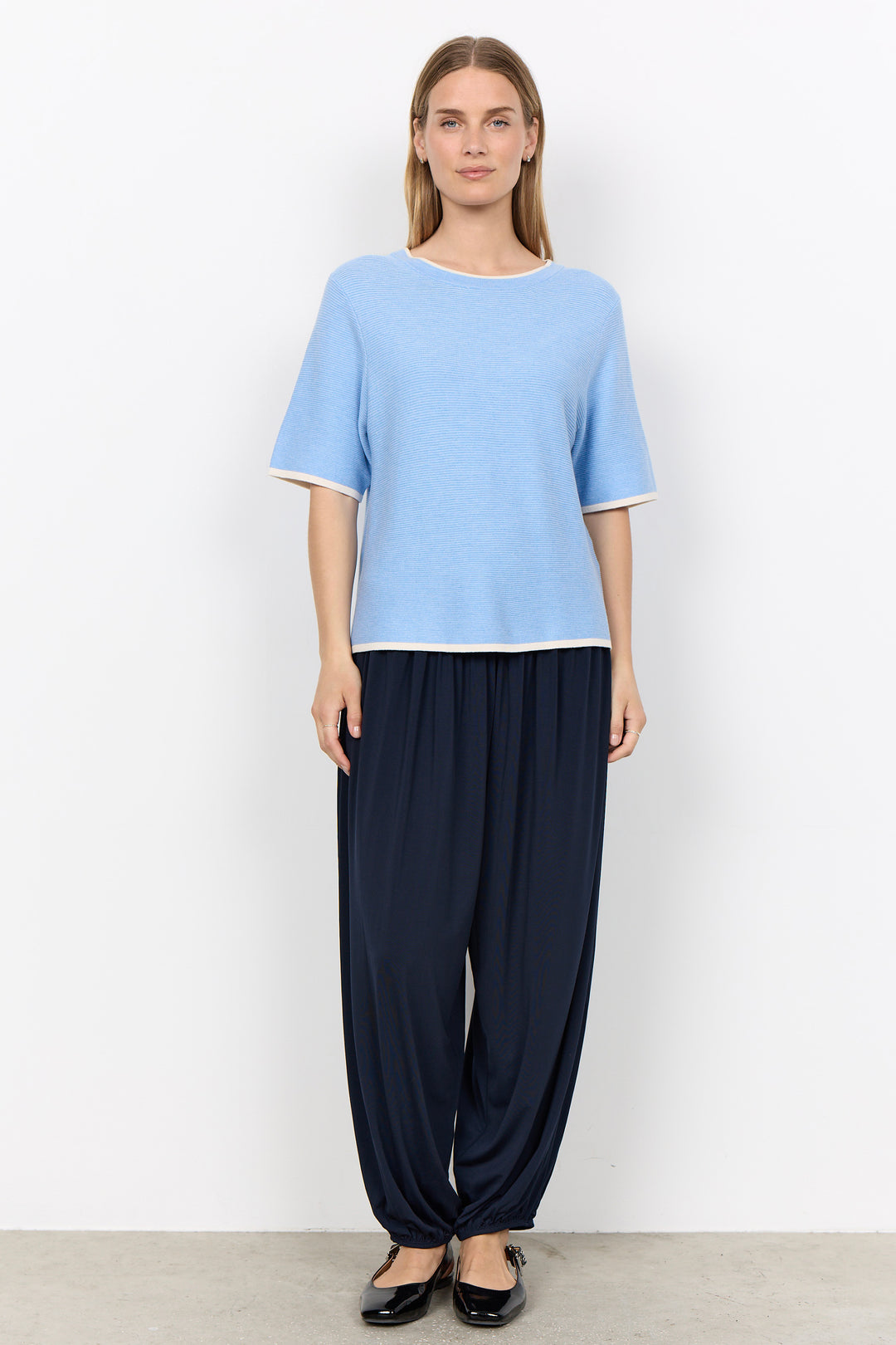 woman wearing a casual ribbed t-shirt sweater on a white background.