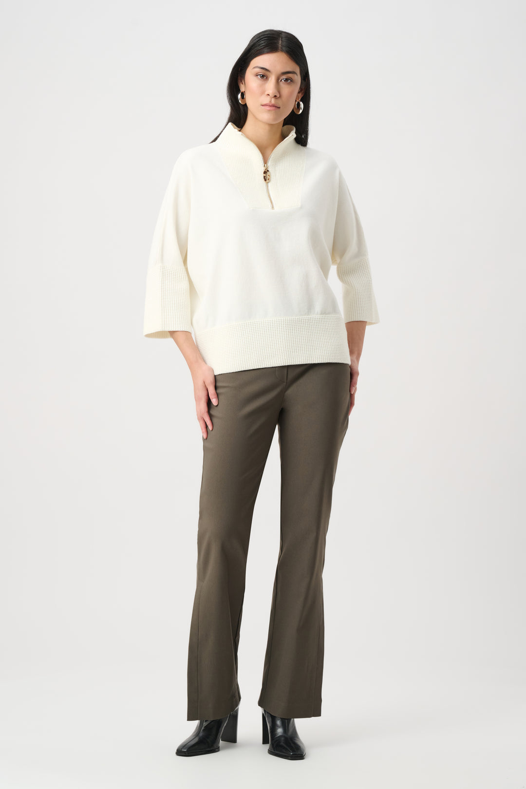 Woman wearing a white blouse and green pants on a white background