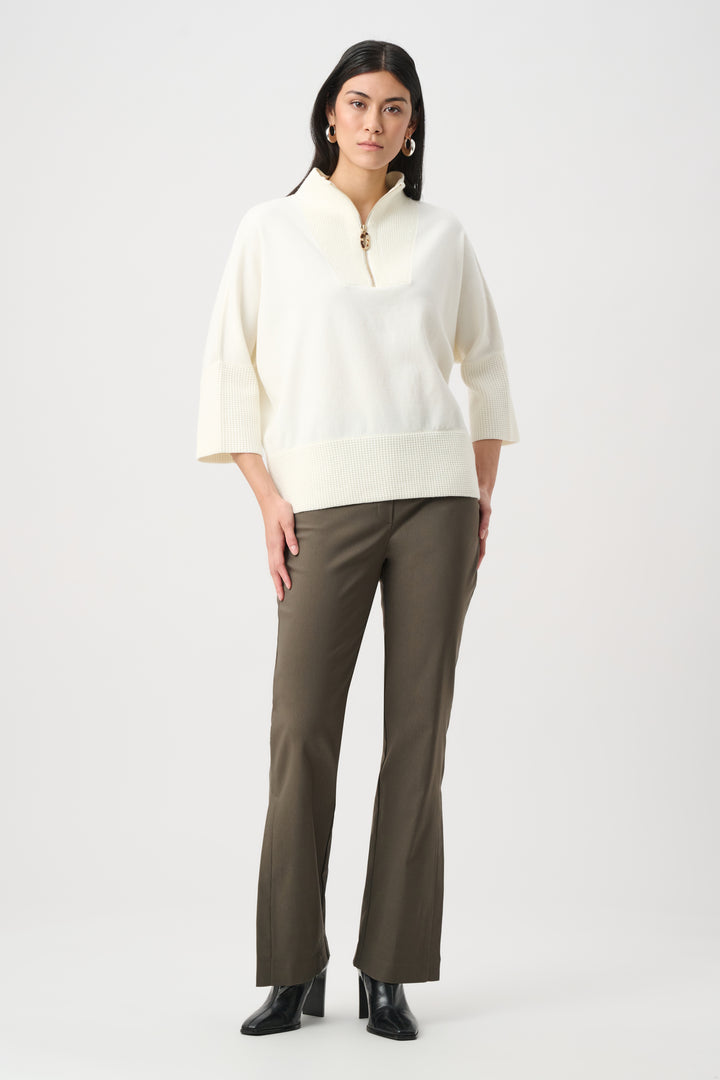 Woman wearing a white blouse and green pants on a white background