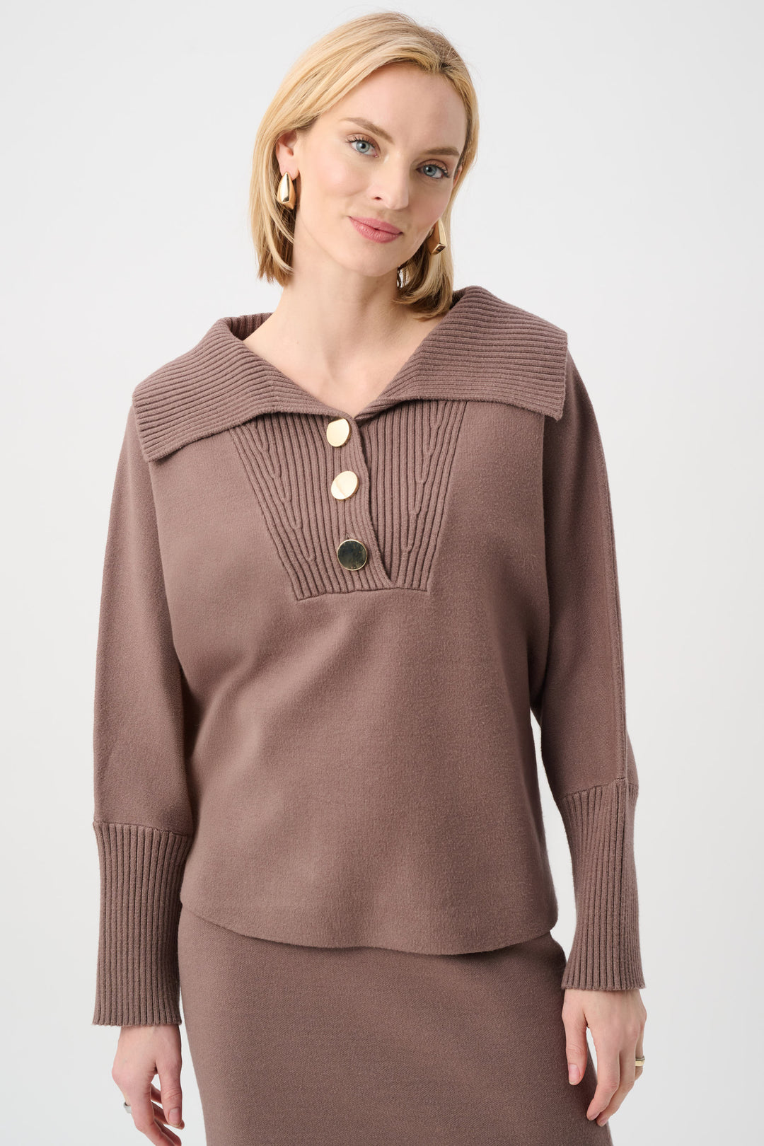 Woman wearing a brown knit sweater with a collar on a white background