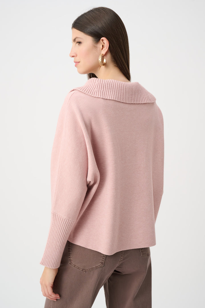 Woman wearing a pink sweater on a white background