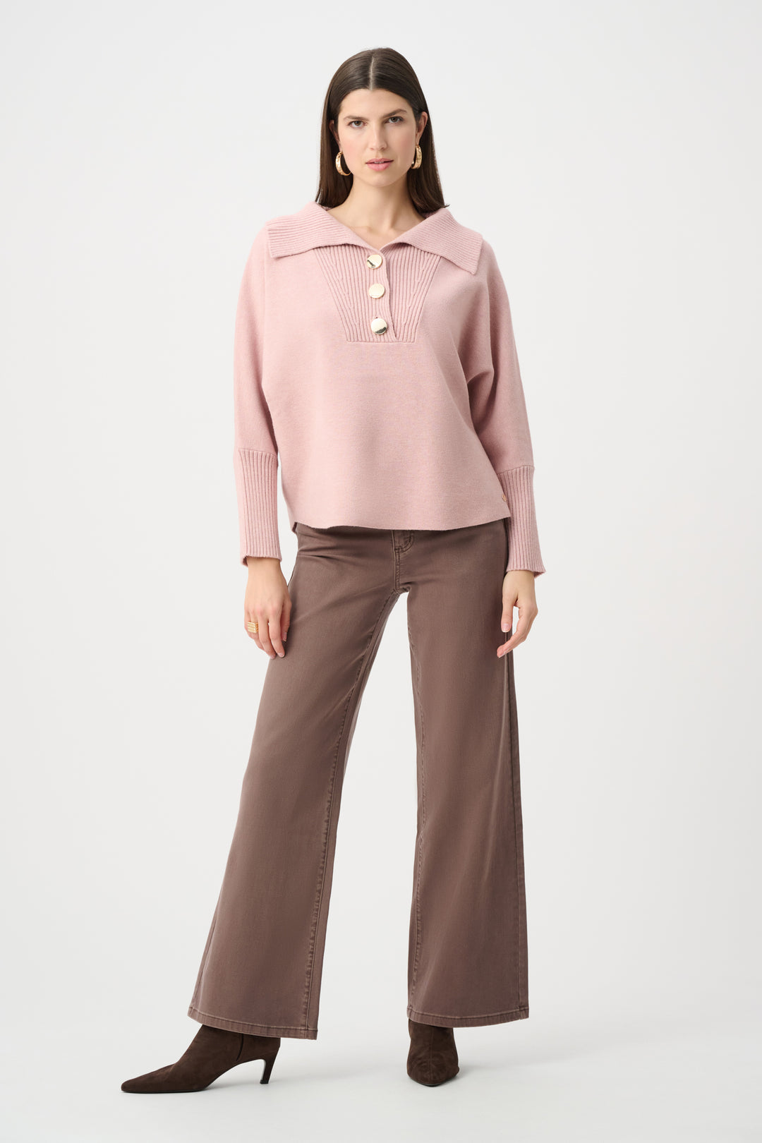 Woman wearing a pink blouse and brown pants on a white background