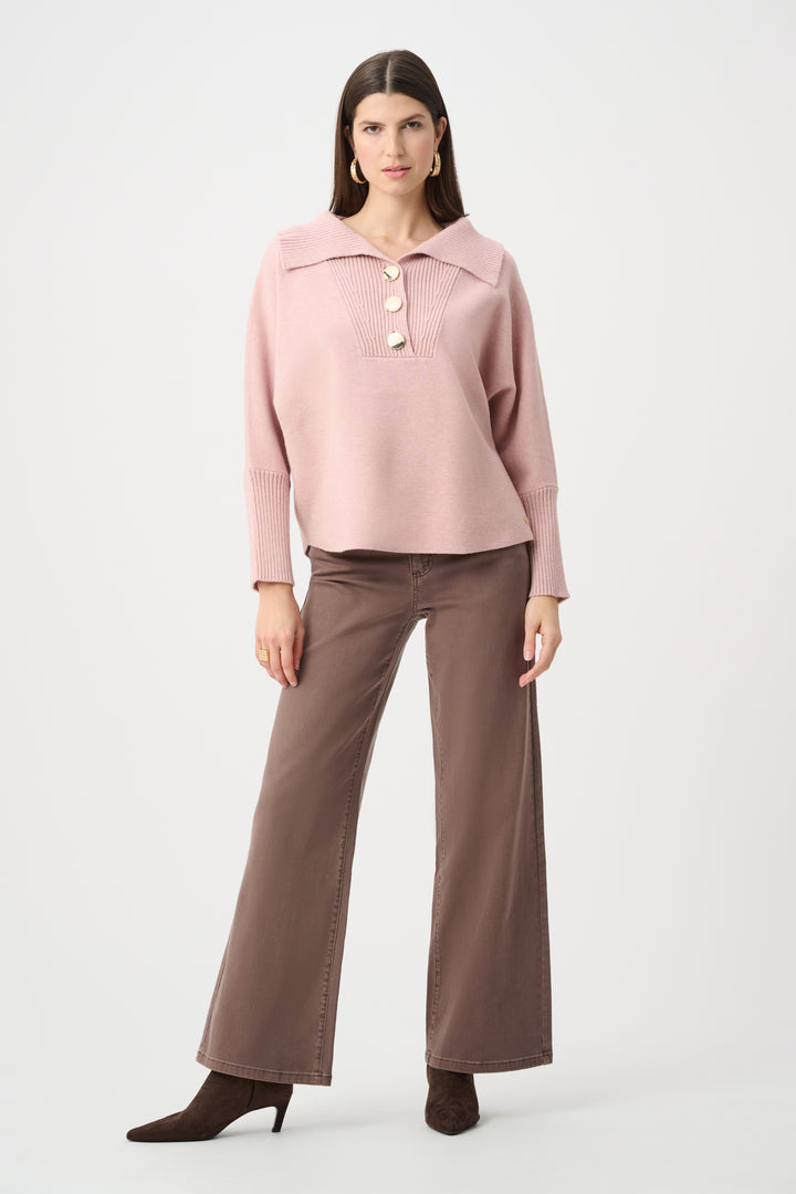 Woman wearing a pink blouse and brown pants on a white background