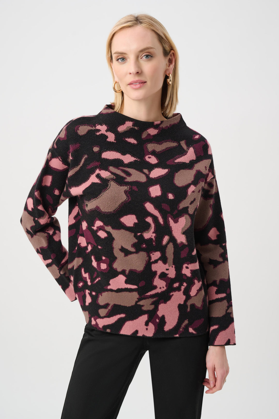 Woman wearing a pink and brown camouflage sweater on a white background