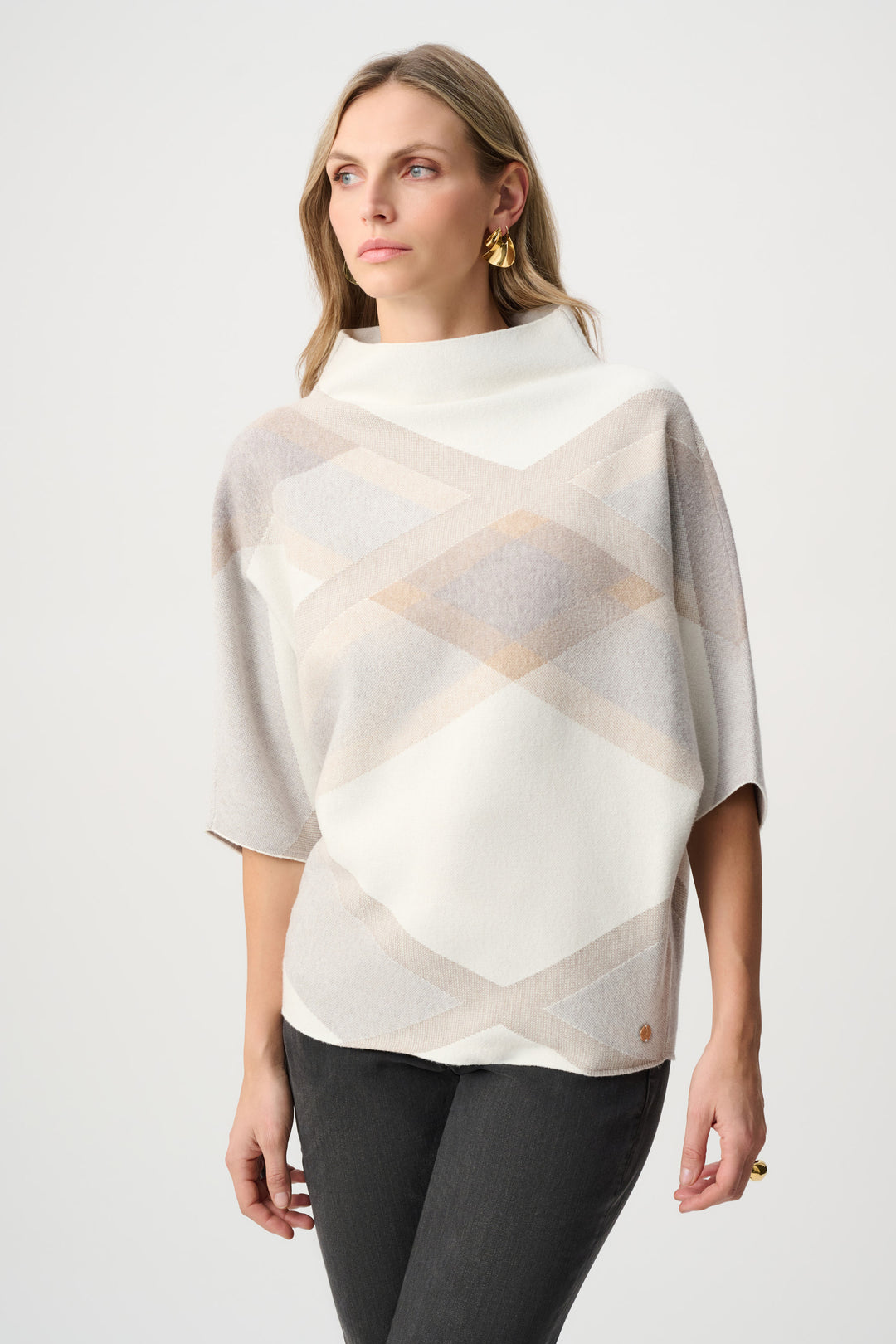 Woman wearing a patterned poncho against a white background