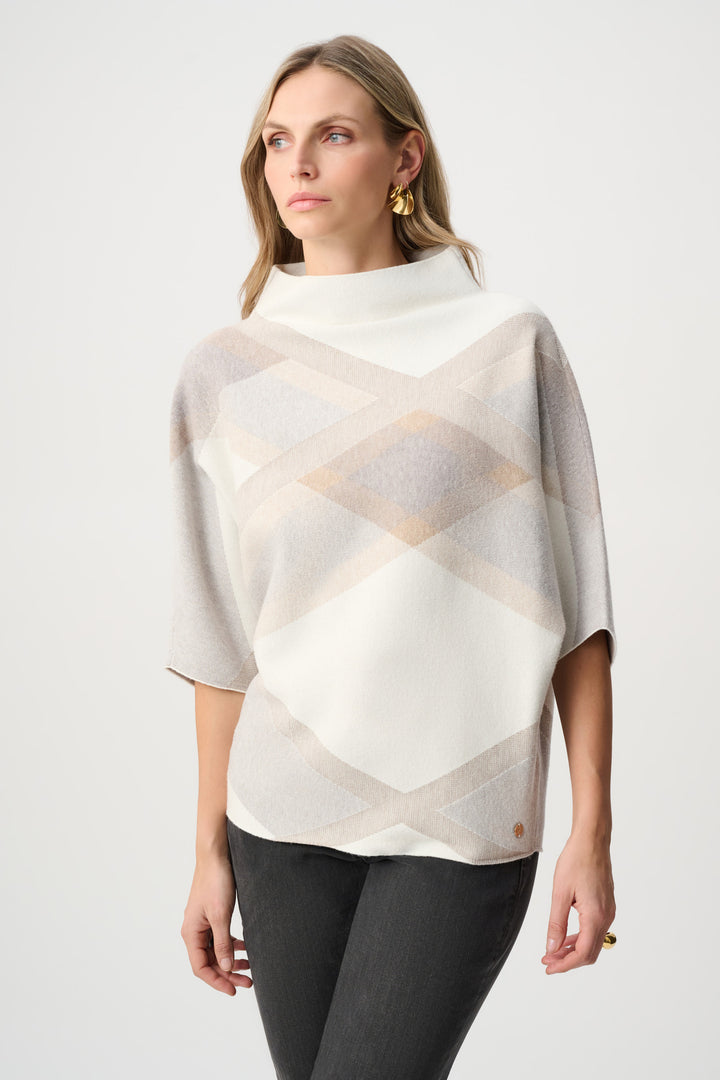 Woman wearing a patterned poncho against a white background