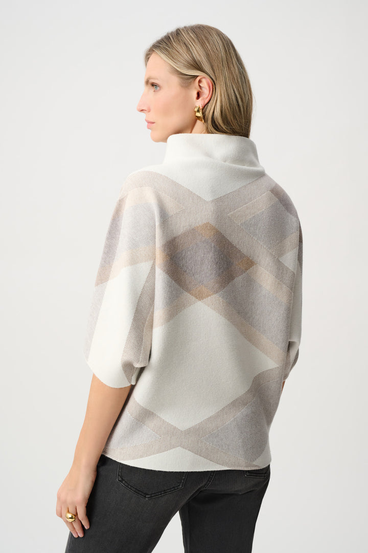 Woman wearing a patterned poncho against a white background
