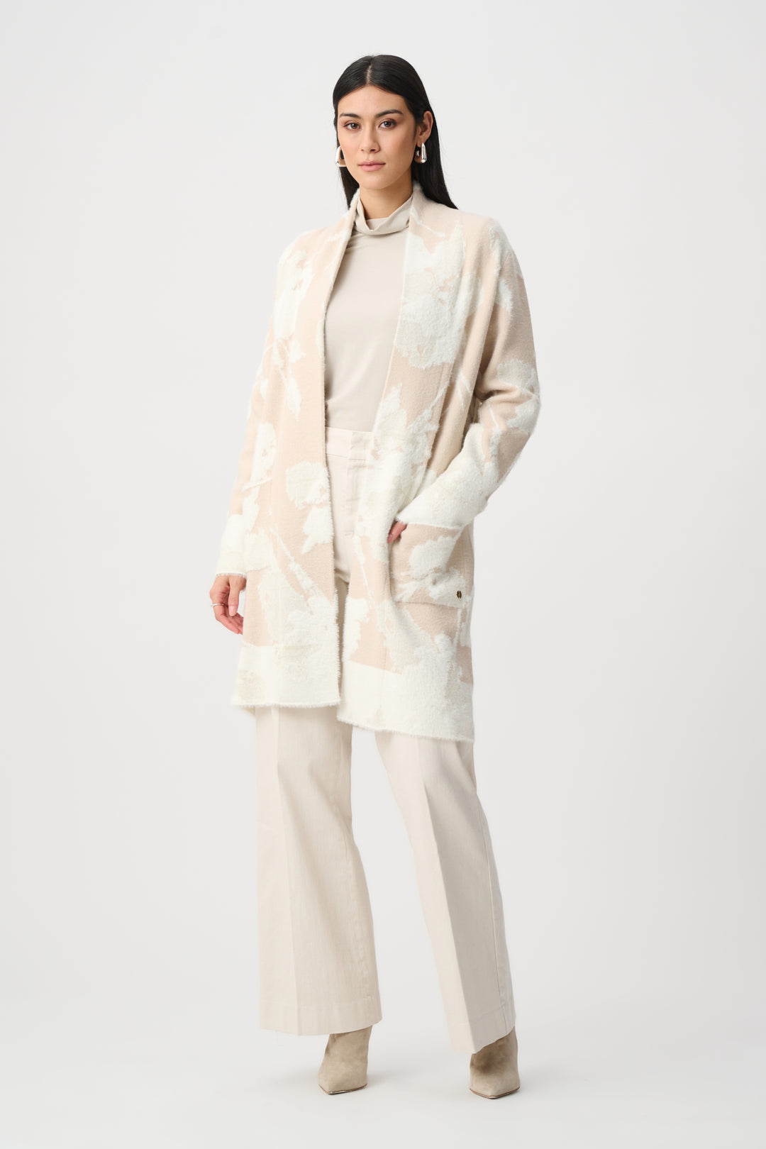 Woman wearing a beige outfit with a matching coat on a white background