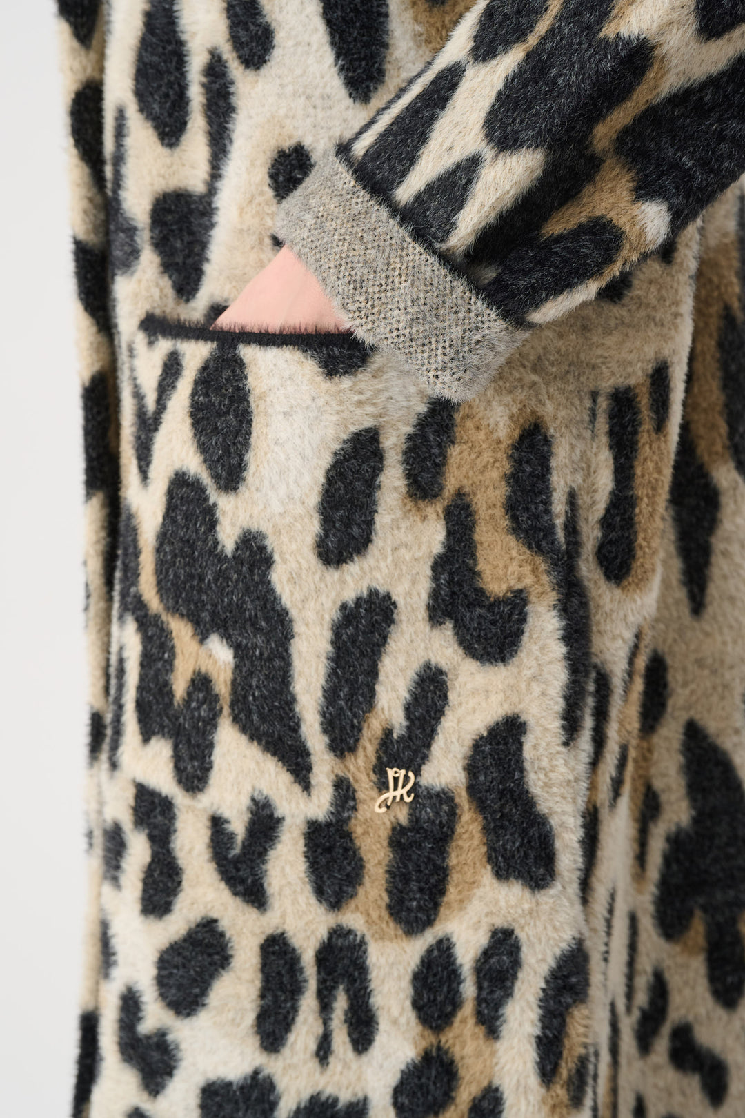 Close-up of a leopard print robe with a brand logo on a plain background