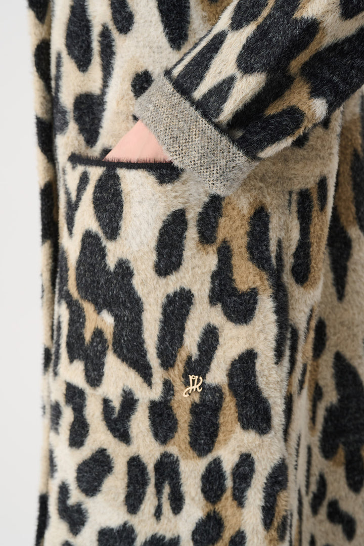 Close-up of a leopard print robe with a brand logo on a plain background