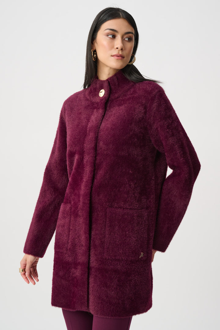 Woman wearing a burgundy coat on a white background
