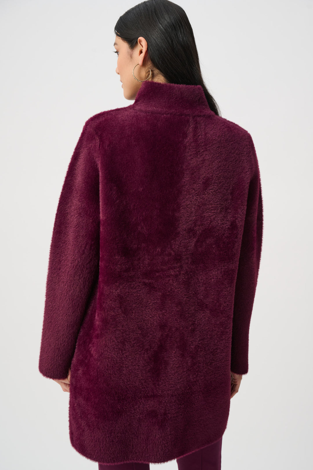 Person wearing a burgundy coat on a white background