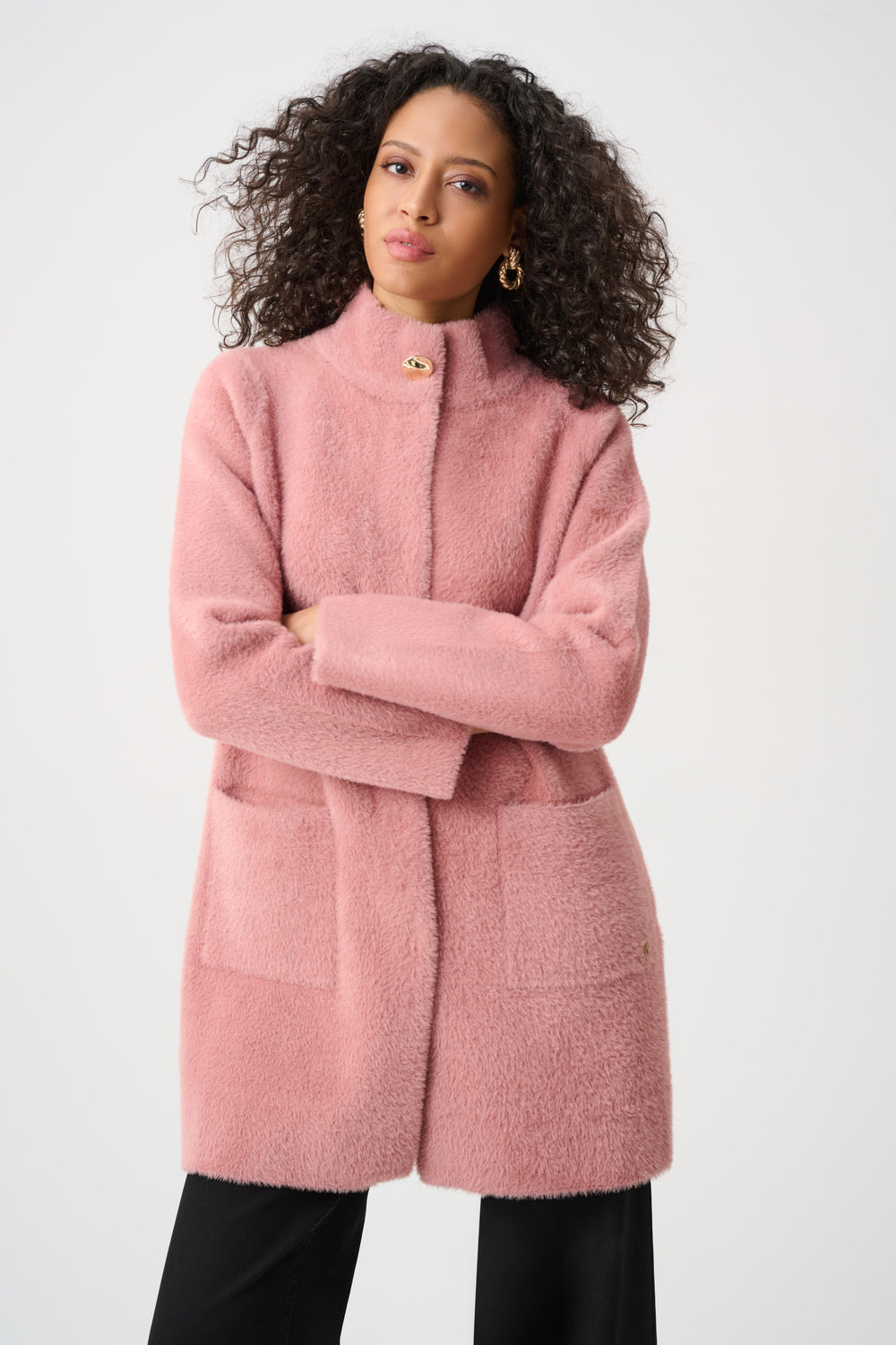 Woman wearing a pink coat against a white background