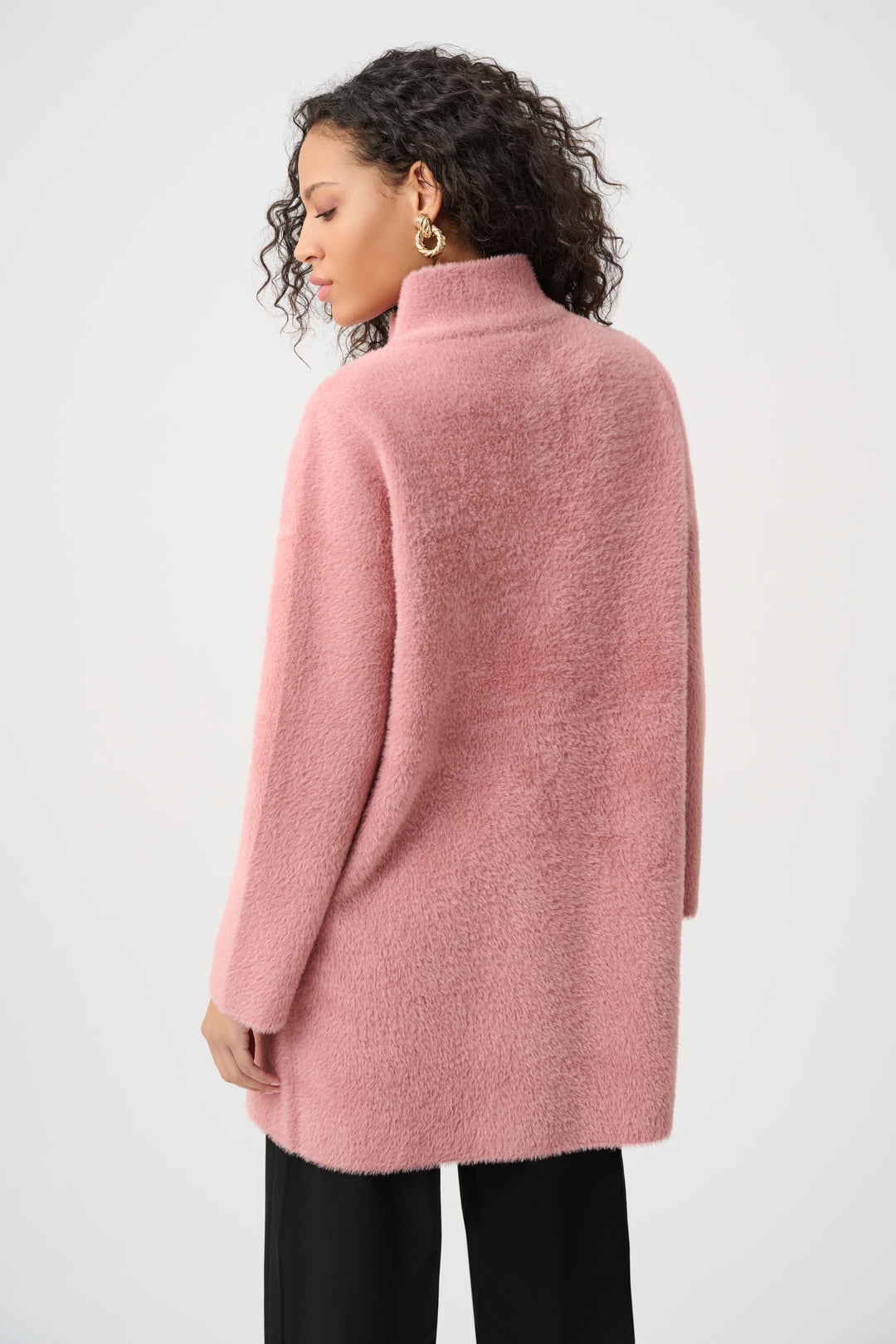 Person wearing a pink coat against a white background