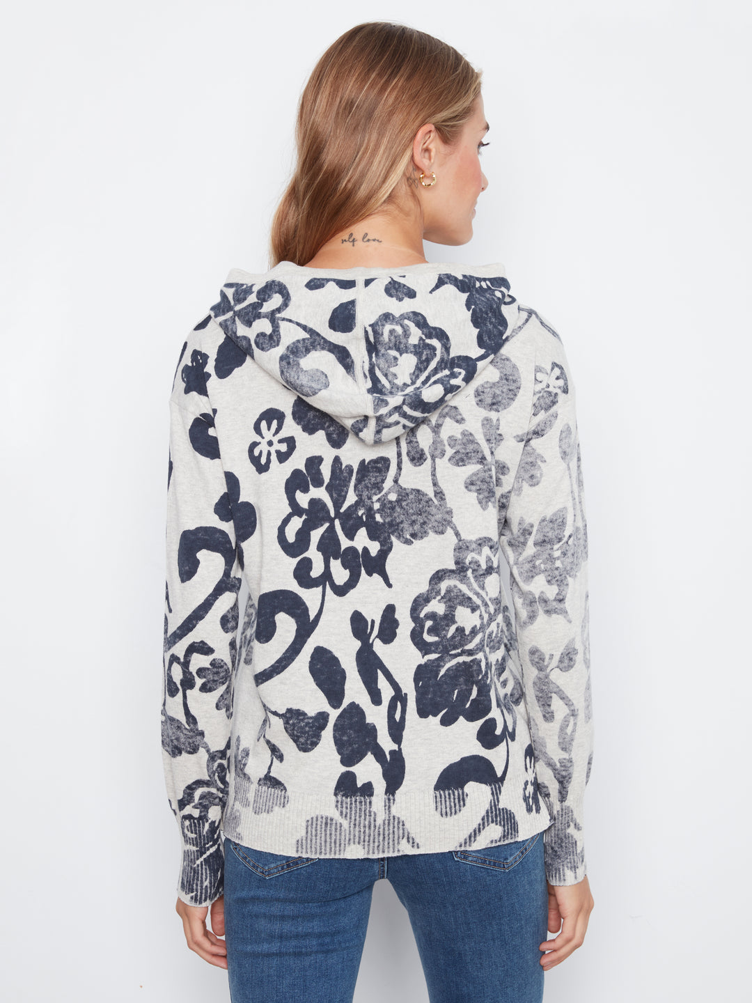 Woman wearing a floral-patterned sweater on a white background
