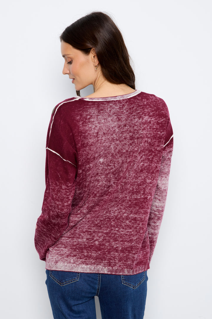 A woman shown from the back wearing a long-sleeve crewneck top with a marled burgundy and white gradient texture, paired with blue jeans, against a plain white background.