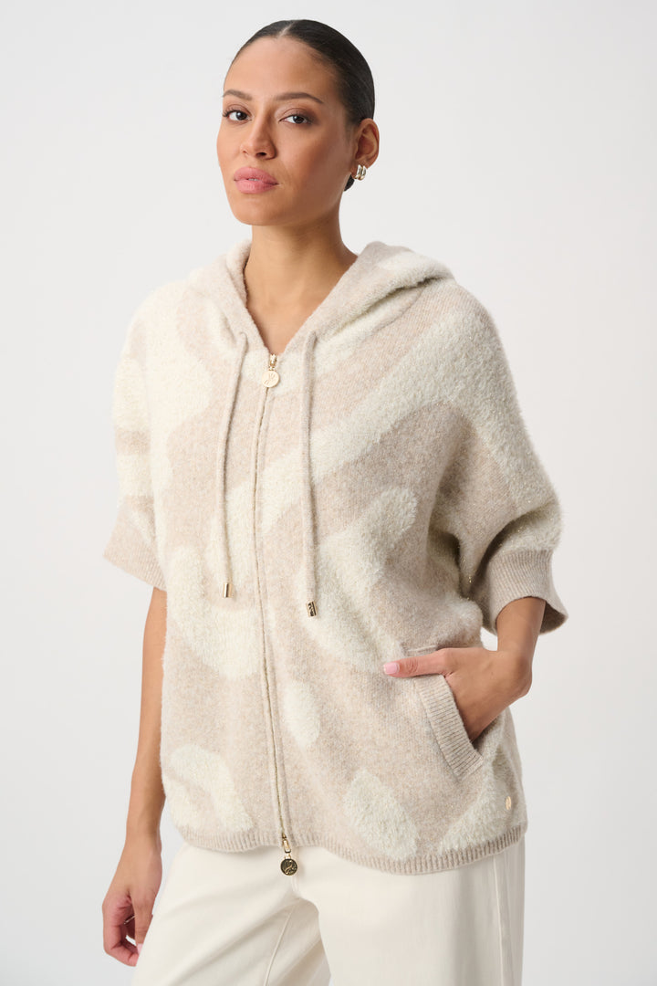 A woman modelling a beige printed sherpa jacket with hood in front of a white background. 