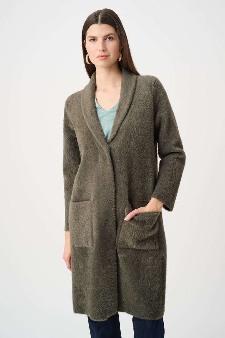 Woman wearing a long olive green coat on a white background