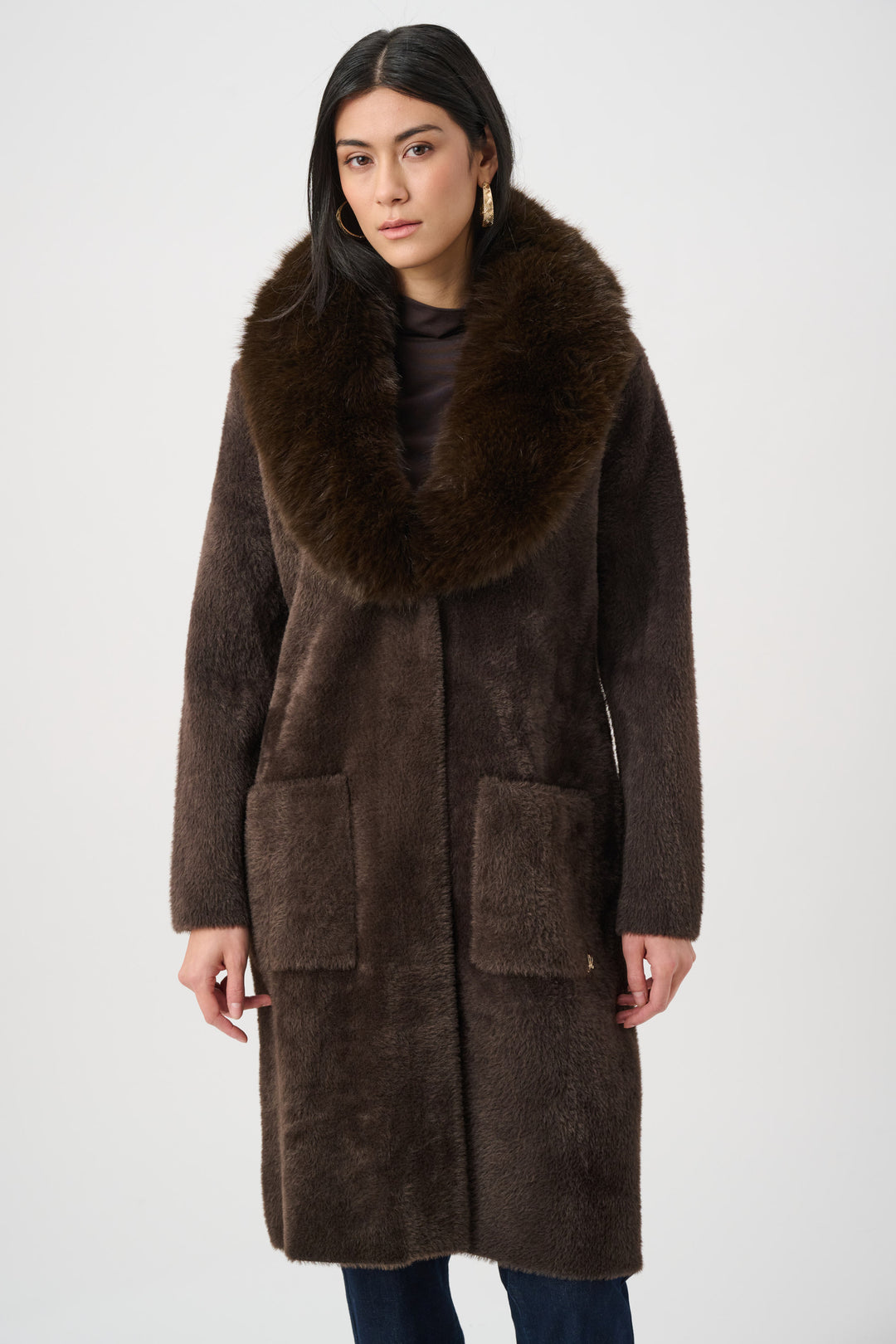 Woman wearing a brown coat with a fur collar on a white background