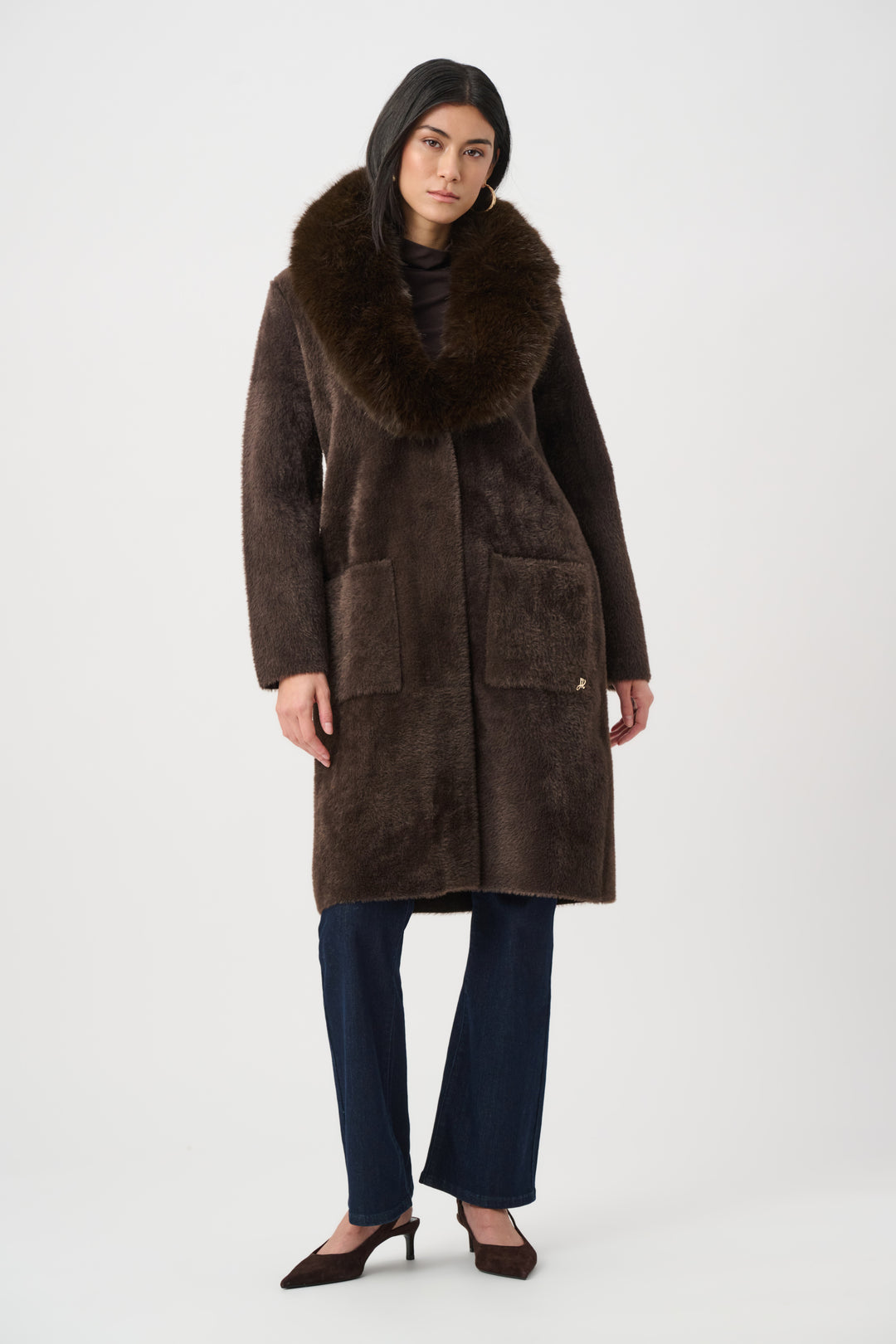 Woman wearing a brown fur-trimmed coat on a white background