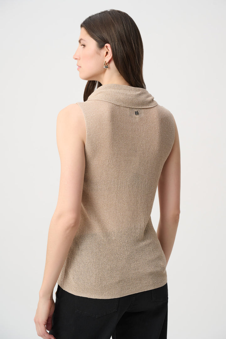 A woman shown from the back wearing a shimmery gold cowl neck sleeveless top and black pants in front of a white background. 