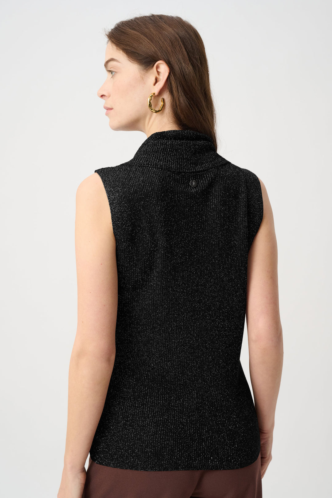 Woman wearing a black sleeveless knitted top on a white background