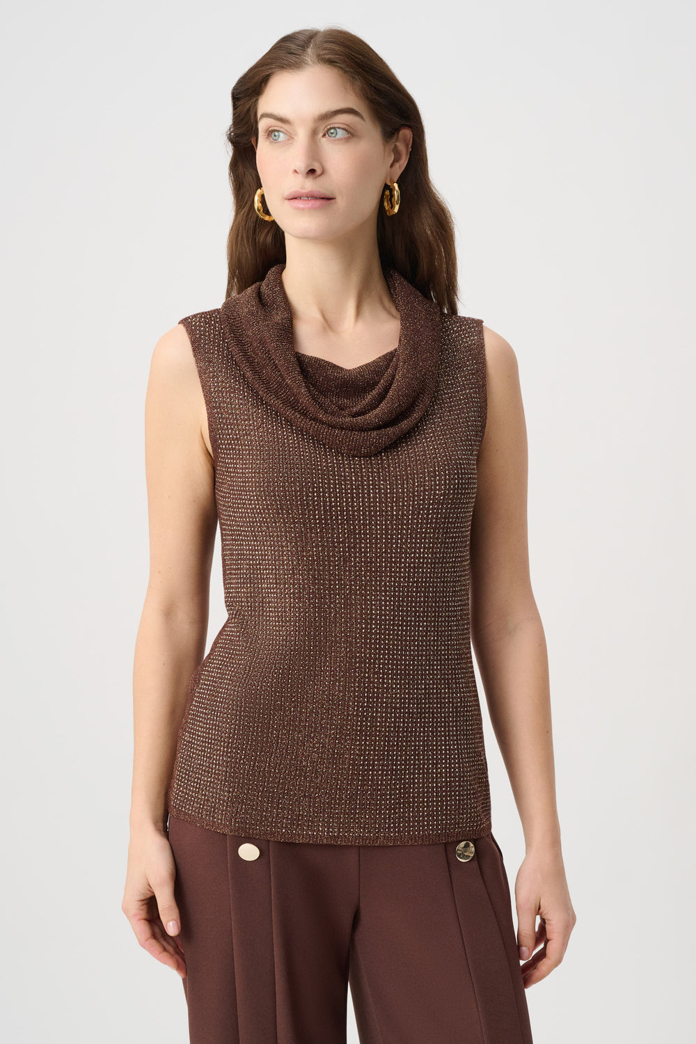 Woman wearing a brown sparkly sleeveless top and wide-leg pants on a white background